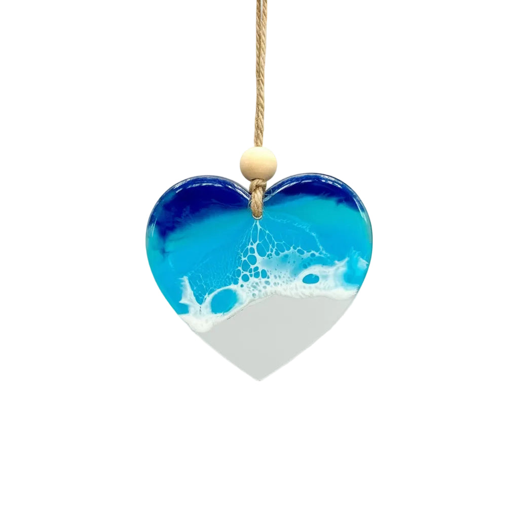 Heart-shaped blue and white pendant on a gold chain against a light gray background