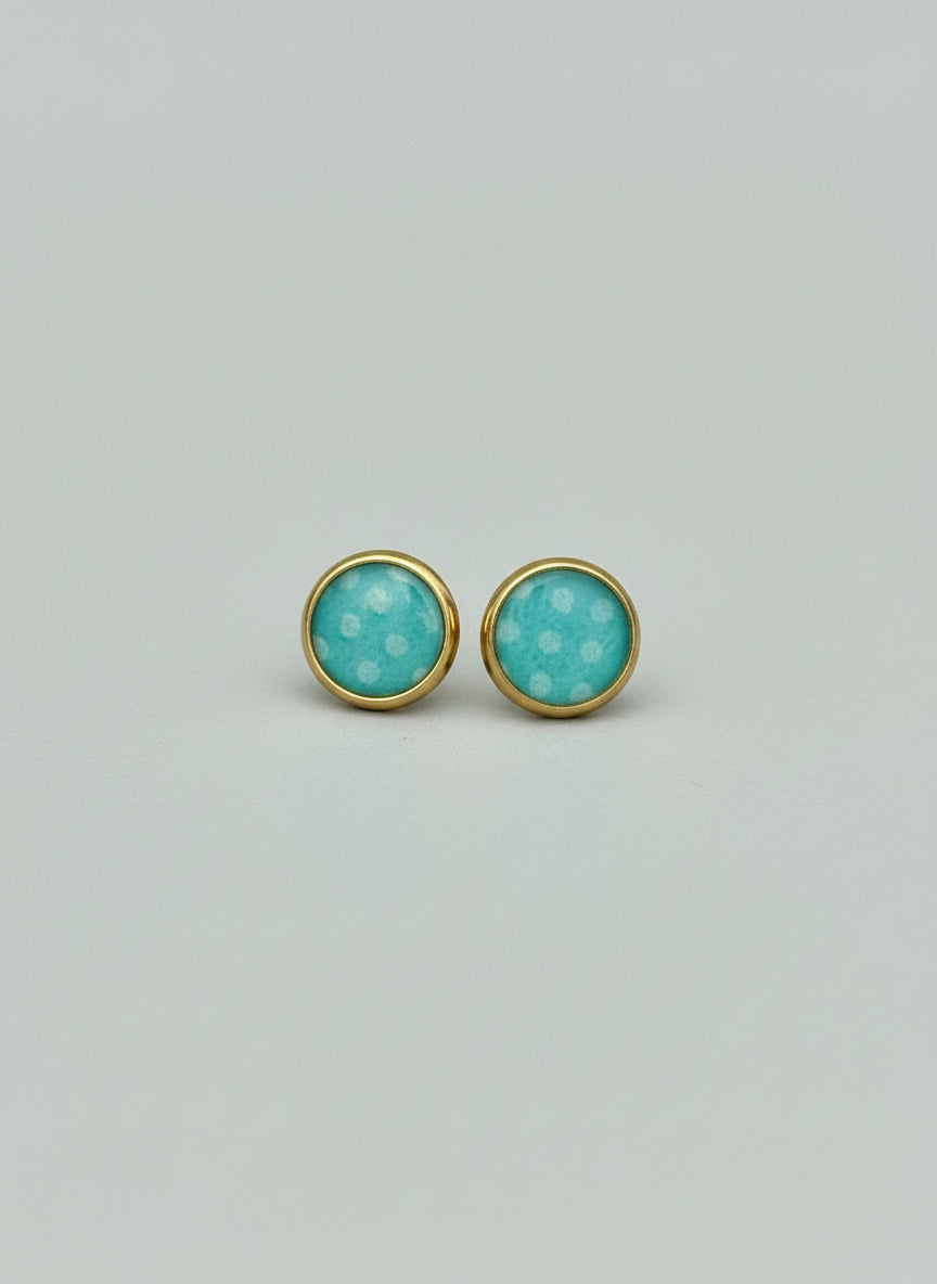 Pair of turquoise earrings with gold accents on a light gray background