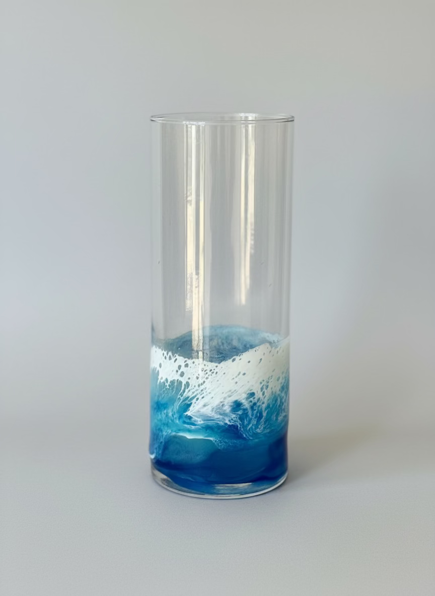 Tall glass hurricane vase with blue and white resin wave design 