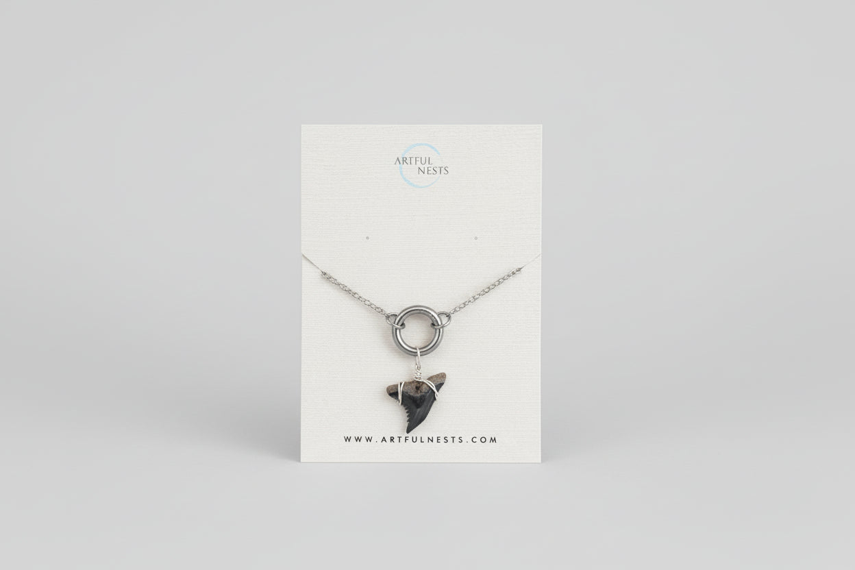 Necklace on a display card with a plant in the background