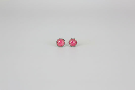 Pair of pink round earrings on a light gray background