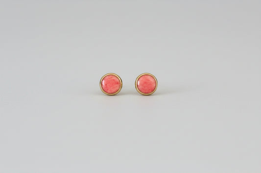 Pair of pink round earrings on a light gray background