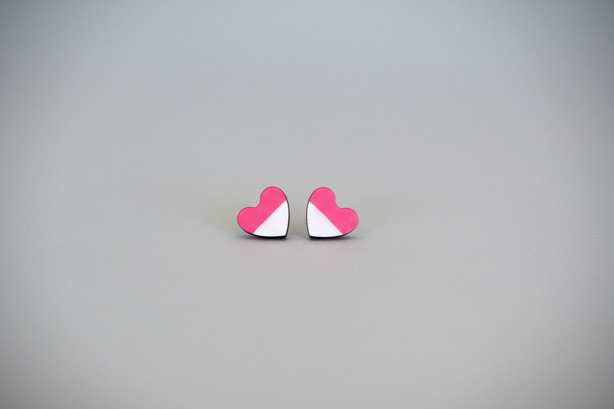 Heart-shaped earrings with pink and white design on a gray background