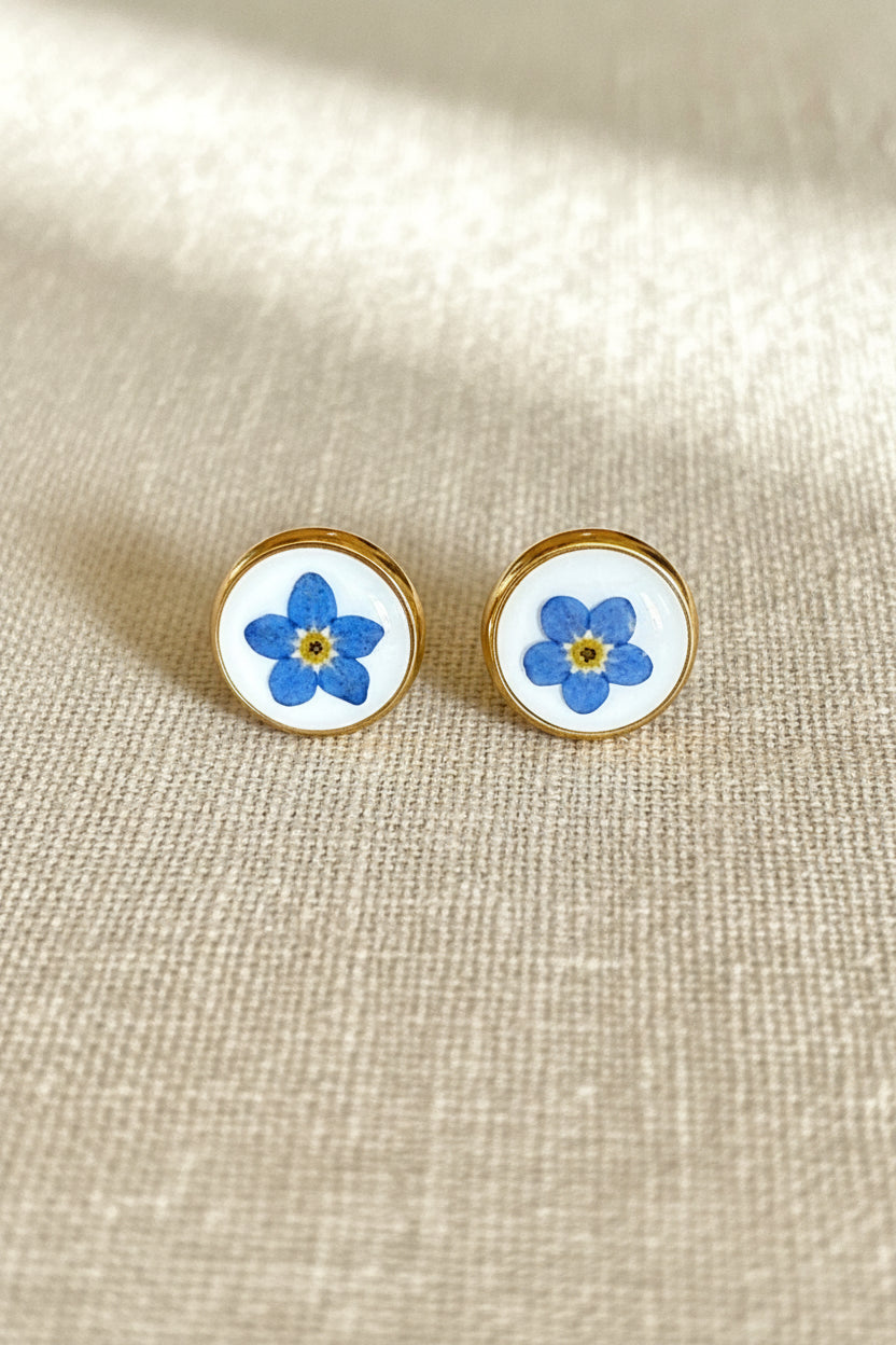 Pair of earrings with floral design on a wooden surface