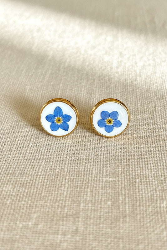 Pair of earrings with floral design on a wooden surface