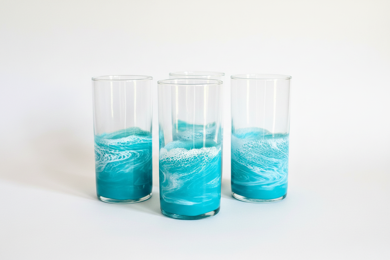 Collection of teal resin wave glass tumblers arranged on white surface with soft studio lighting